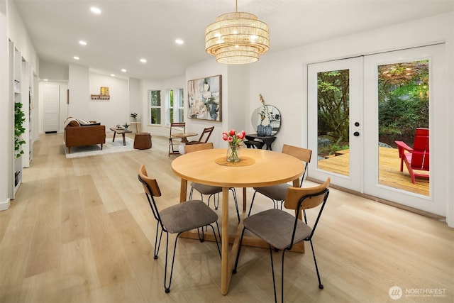 dining space with recessed lighting, an inviting chandelier, french doors, and light wood-type flooring