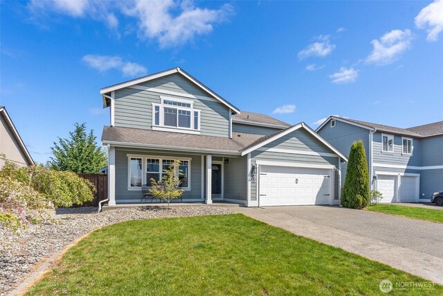 traditional home with a porch, driveway, fence, a front lawn, and an attached garage