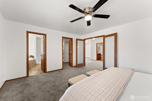 carpeted bedroom with connected bathroom, a walk in closet, a ceiling fan, baseboards, and a closet