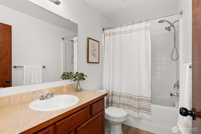 full bathroom with toilet, wood finished floors, shower / bath combo, and vanity