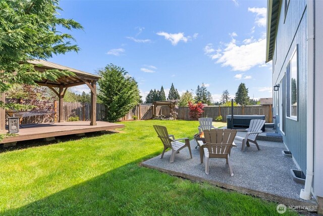view of yard with a fenced backyard, a gazebo, a hot tub, and a deck
