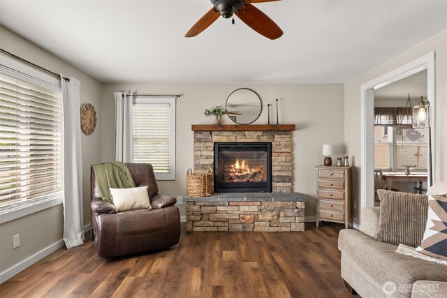 living area with a healthy amount of sunlight, ceiling fan, a fireplace, and wood finished floors