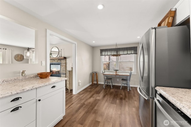 kitchen with dark wood finished floors, baseboards, stainless steel appliances, recessed lighting, and white cabinetry