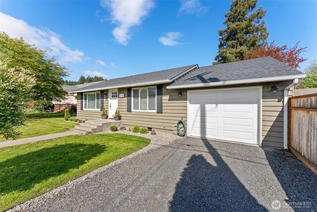 single story home featuring fence, roof with shingles, an attached garage, a front yard, and driveway