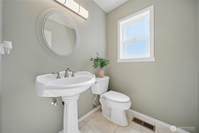 half bathroom featuring visible vents, baseboards, tile patterned floors, and toilet