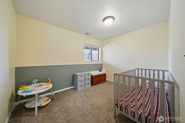 carpeted bedroom with baseboards, visible vents, and a crib