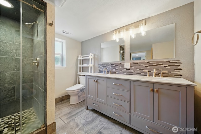 bathroom with visible vents, a sink, and a stall shower