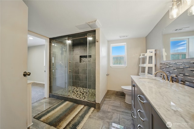 full bath with toilet, visible vents, and a shower stall