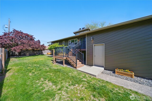view of yard with a fenced backyard and stairs
