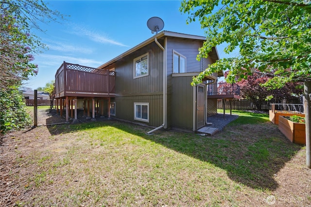back of house with a lawn, fence, and a wooden deck