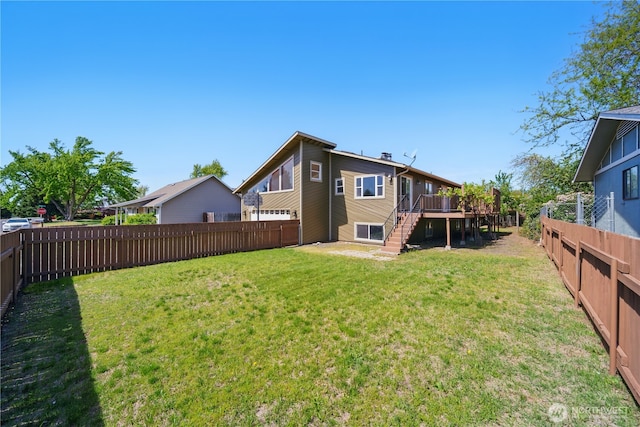 rear view of house with a fenced backyard, stairs, a lawn, and a deck