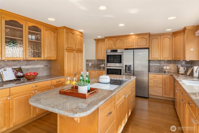 5310 143rd Ave SE, Bellevue, WA 98006 - kitchen featuring appliances with stainless steel finishes, decorative backsplash, light stone counters, a kitchen island, and light wood-type flooring