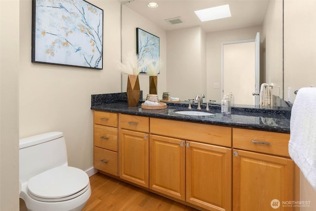 5310 143rd Ave SE, Bellevue, WA 98006 - bathroom featuring a skylight, wood finished floors, toilet, vanity, and baseboards