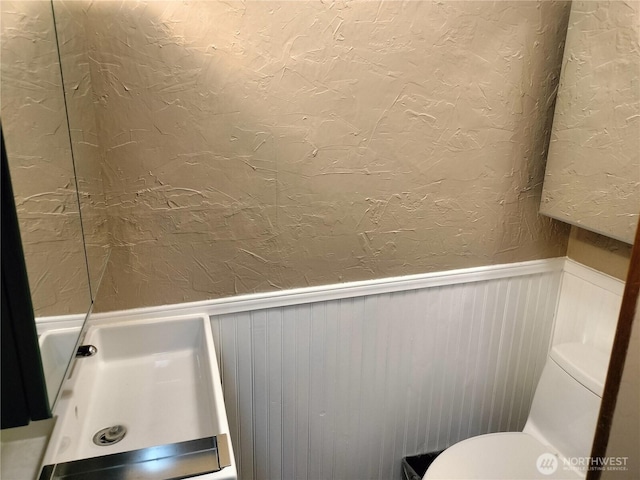 21926 Vashon Hwy SW, Vashon, WA 98070 - bathroom featuring a wainscoted wall, toilet, a textured wall, and a decorative wall