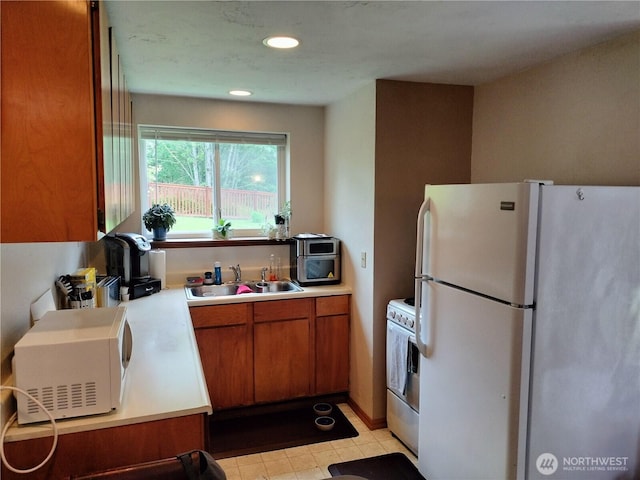21926 Vashon Hwy SW, Vashon, WA 98070 - kitchen with white appliances, a sink, brown cabinetry, light countertops, and recessed lighting