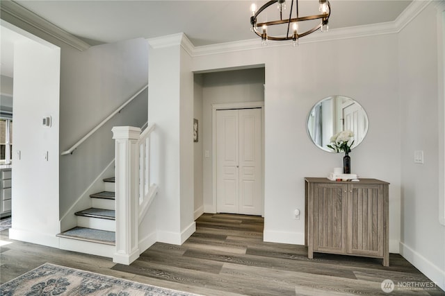 interior space featuring an inviting chandelier, ornamental molding, and wood finished floors