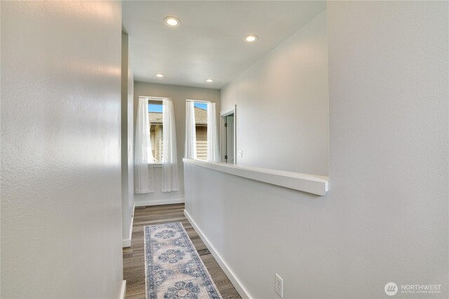 hall with dark wood finished floors, baseboards, and recessed lighting