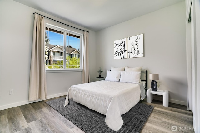 bedroom with baseboards and wood finished floors