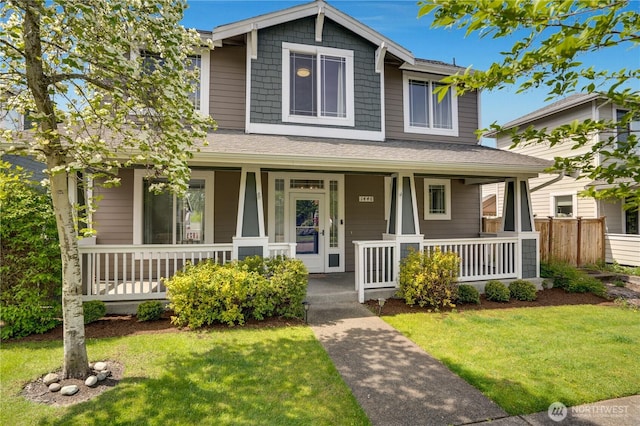 view of front of home featuring a porch, fence, and a front yard