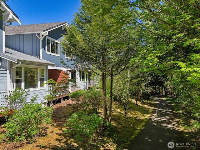 view of property exterior featuring a shingled roof and board and batten siding