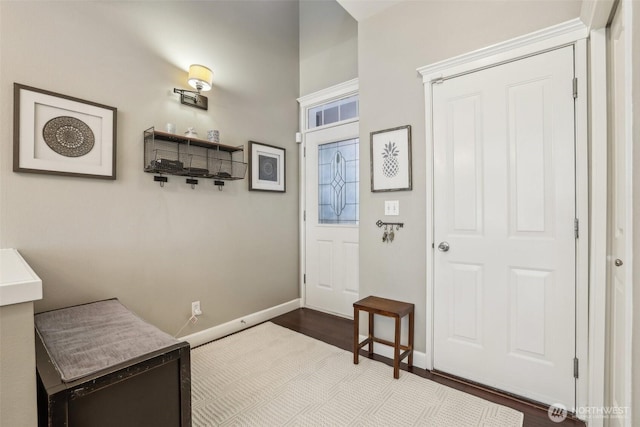 foyer entrance featuring dark wood-type flooring and baseboards