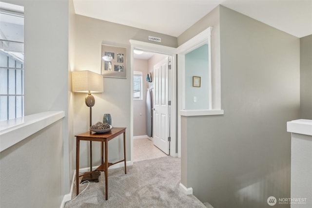 hallway with carpet floors and baseboards