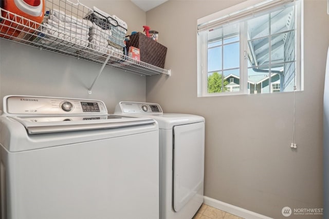 laundry room with washer and dryer, baseboards, and light tile patterned floors