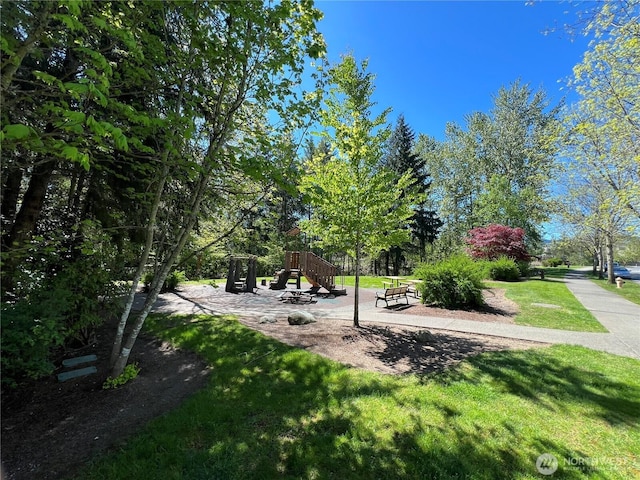 view of home's community with a playground and a lawn