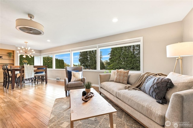 living area featuring visible vents, baseboards, recessed lighting, a chandelier, and light wood-style flooring