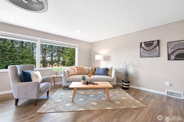 living area featuring baseboards, wood finished floors, and visible vents
