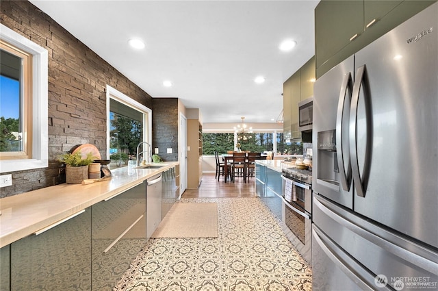 kitchen featuring appliances with stainless steel finishes, an inviting chandelier, a sink, recessed lighting, and green cabinets