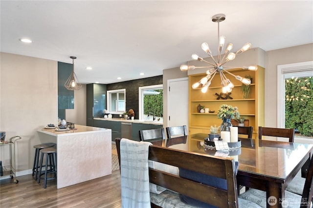 dining area with plenty of natural light, recessed lighting, wood finished floors, and an inviting chandelier