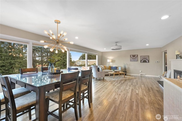 dining room featuring visible vents, light wood-style floors, baseboards, recessed lighting, and a chandelier