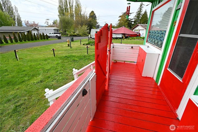 wooden terrace featuring a yard