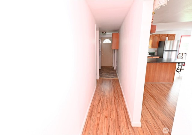 hallway featuring baseboards and light wood-style floors