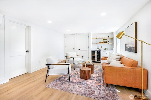 living area with wine cooler, recessed lighting, a dry bar, and light wood-type flooring