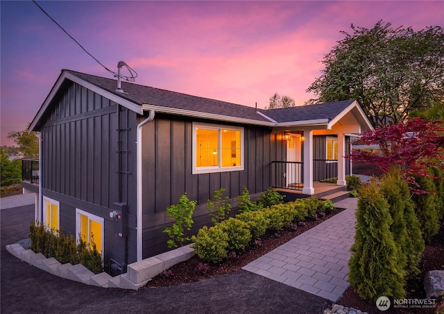 ranch-style home with roof with shingles and board and batten siding