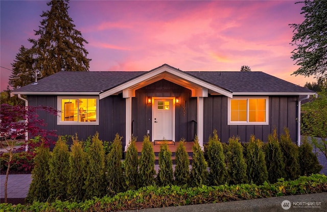 bungalow-style home with a shingled roof and board and batten siding