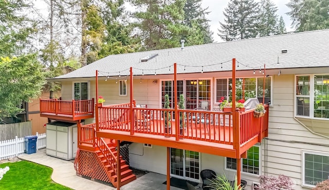 back of house featuring stairway, fence, a wooden deck, and roof with shingles