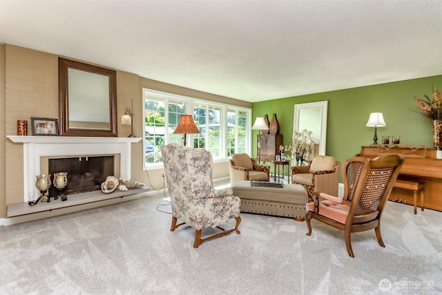 living room featuring a textured ceiling, carpet, and a fireplace with raised hearth