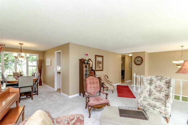 living area featuring baseboards, light colored carpet, a textured ceiling, and a chandelier