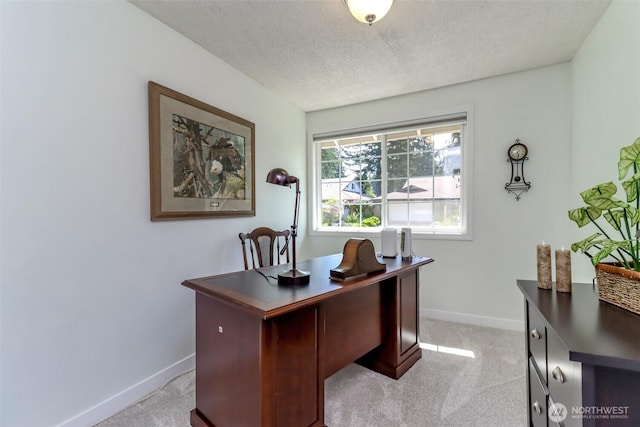 home office featuring light colored carpet, a textured ceiling, and baseboards