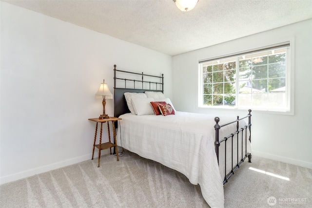 carpeted bedroom featuring baseboards and a textured ceiling