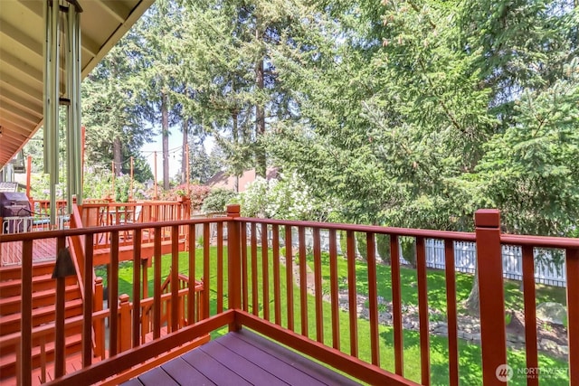 wooden deck featuring a lawn and fence