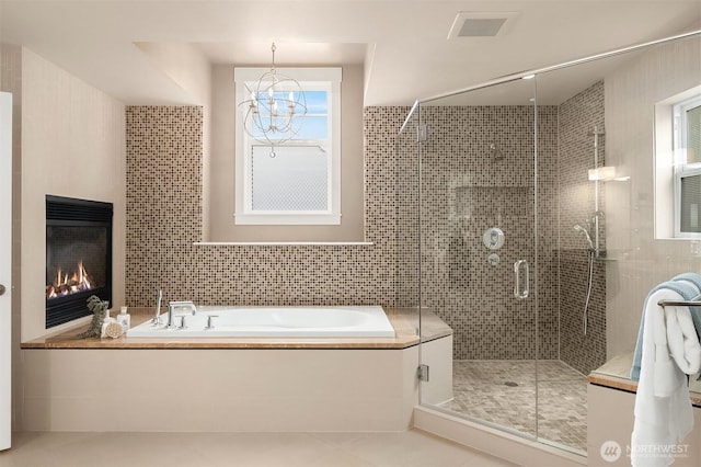 325 6th Ave S, Kirkland, WA 98033 - bathroom featuring a bath, tile walls, tile patterned flooring, a stall shower, and a glass covered fireplace