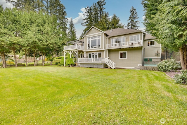 rear view of house with fence, stairway, a deck, a balcony, and a lawn