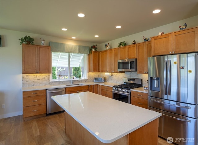 71 Lillian Ridge Dr, Sequim, WA 98382 - kitchen featuring brown cabinets, a sink, stainless steel appliances, light countertops, and wood finished floors