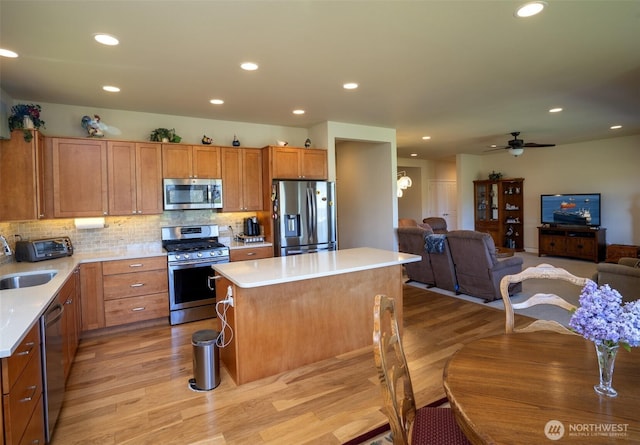 71 Lillian Ridge Dr, Sequim, WA 98382 - kitchen featuring light wood finished floors, a center island, a ceiling fan, light countertops, and appliances with stainless steel finishes