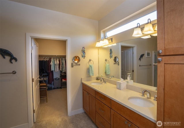71 Lillian Ridge Dr, Sequim, WA 98382 - full bathroom featuring double vanity, a spacious closet, baseboards, and a sink