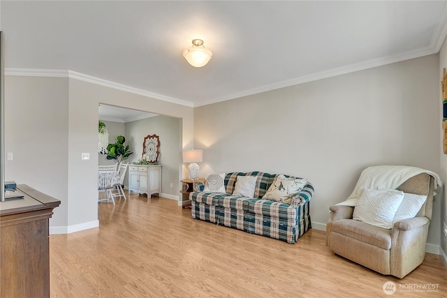living room with light wood finished floors, baseboards, and crown molding